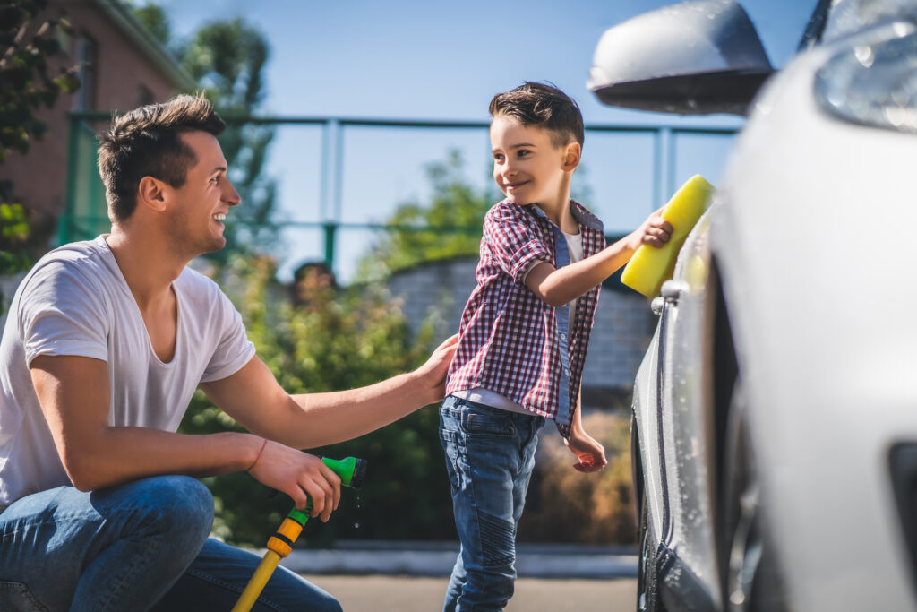 Dad and his son cleaning the car for father's day in leamington